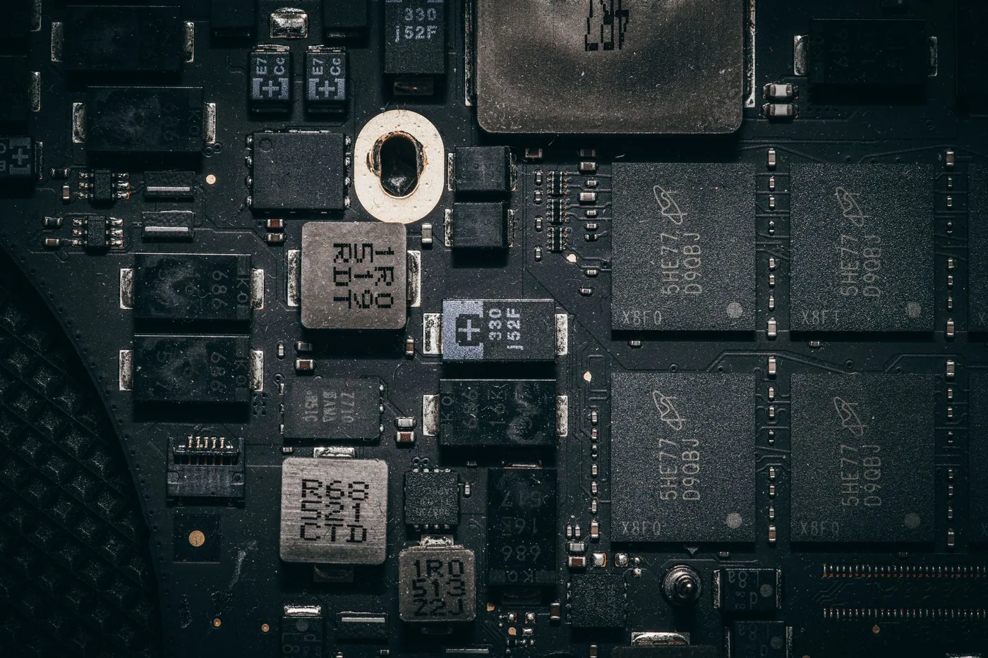 Close-up of a populated printed circuit board showing surface-mount components, connectors and copper traces.
