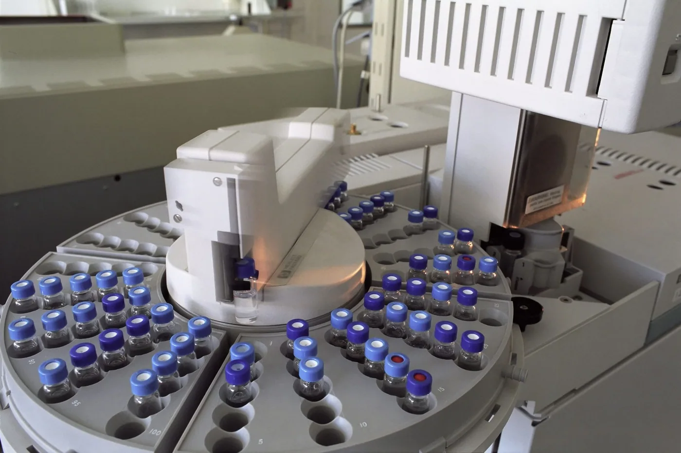 An optical analysis instrument on a laboratory bench with a sample holder and connected cabling.