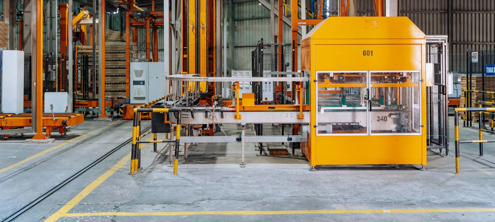 Operator monitoring machines on a modern manufacturing floor.