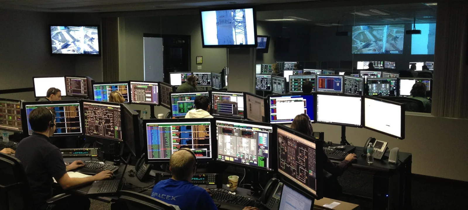 Team reviewing operational software on multiple displays.